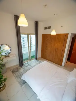 a bedroom with a white bed and a large window at Stunning 2bd marina views prime location high floor in Dubai