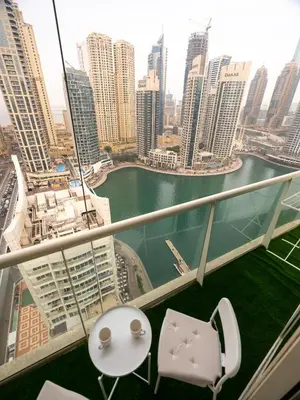 a balcony with two chairs and a view of a city at Stunning 2bd marina views prime location high floor in Dubai