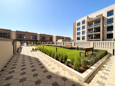 a courtyard with benches and grass in front of a building at Frank Porter - Eleganz 5 By Danube in Dubai