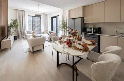 a kitchen and living room with a table and chairs at Frank Porter - Rosewater at Creek Beach 3 in Dubai