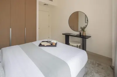 a bedroom with a white bed and a mirror at Frank Porter - Rosewater at Creek Beach 3 in Dubai