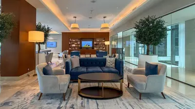 a lobby with a blue couch and chairs and a table at Luxury 2BR at Address Opera with Burj Khalifa view in Dubai