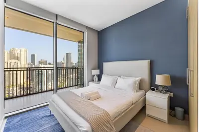 a bedroom with a large bed and a balcony at Beachfront Vibe 2BR APT - Walk to JBR & Bluewaters in Dubai