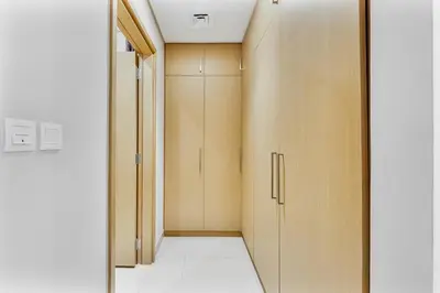 a room with wooden cabinets and a hallway at Beachfront Vibe 2BR APT - Walk to JBR & Bluewaters in Dubai