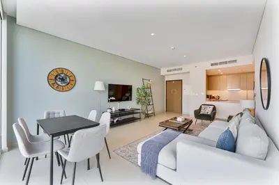 a living room with a white couch and a table at Beachfront Vibe 2BR APT - Walk to JBR & Bluewaters in Dubai