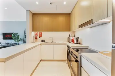 a kitchen with white cabinets and a sink at Beachfront Vibe 2BR APT - Walk to JBR & Bluewaters in Dubai