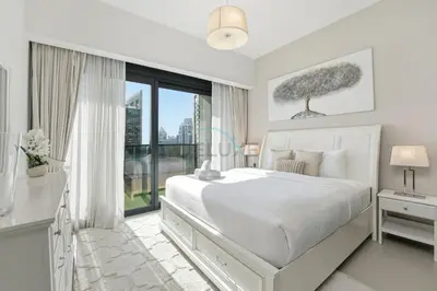 a white bedroom with a large bed and a window at Steps from Dubai Mall and Burj Khalifa, with Seamless Metro Access to Dubai Marina and Palm Jumeirah - Act One Act Two Tower 1, Downtown Dubai by Deluxe Holiday Homes in Dubai