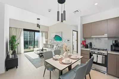 a kitchen and living room with a table and chairs at Steps from Dubai Mall and Burj Khalifa, with Seamless Metro Access to Dubai Marina and Palm Jumeirah - Act One Act Two Tower 1, Downtown Dubai by Deluxe Holiday Homes in Dubai
