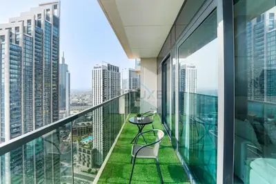 a balcony in a skyscraper with a table and chairs at Steps from Dubai Mall and Burj Khalifa, with Seamless Metro Access to Dubai Marina and Palm Jumeirah - Act One Act Two Tower 1, Downtown Dubai by Deluxe Holiday Homes in Dubai