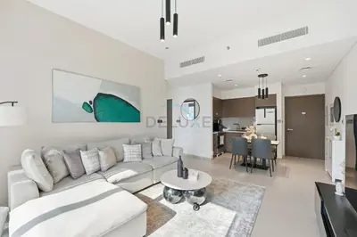 a living room with a white couch and a table at Steps from Dubai Mall and Burj Khalifa, with Seamless Metro Access to Dubai Marina and Palm Jumeirah - Act One Act Two Tower 1, Downtown Dubai by Deluxe Holiday Homes in Dubai