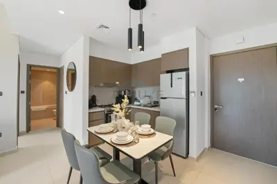 a kitchen and dining room with a table and chairs at Steps from Dubai Mall and Burj Khalifa, with Seamless Metro Access to Dubai Marina and Palm Jumeirah - Act One Act Two Tower 1, Downtown Dubai by Deluxe Holiday Homes in Dubai