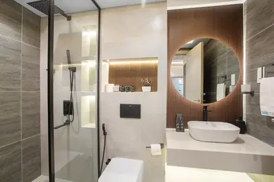a bathroom with a shower and a sink and a mirror at Stylish Stay 2 Bedroom Minutes from Burj Khalifa in Dubai