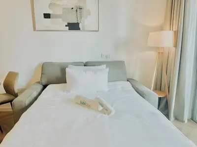 a white bed with two books on top of it at Stylish Stay 2 Bedroom Minutes from Burj Khalifa in Dubai