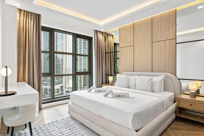 a bedroom with a large white bed and a desk at Stylish Stay 2 Bedroom Minutes from Burj Khalifa in Dubai