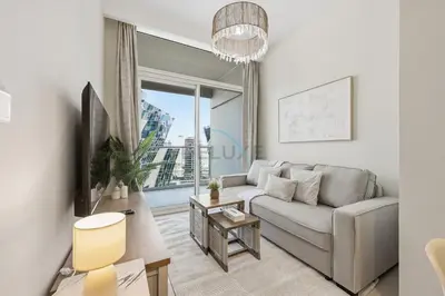a living room with a couch and a large window at Located Near Dubai Mall, Burj Khalifa and Dubai Canal, with Easy Access to Dubai Metro - Vera Tower, Business Bay by Deluxe Holiday Homes in Dubai