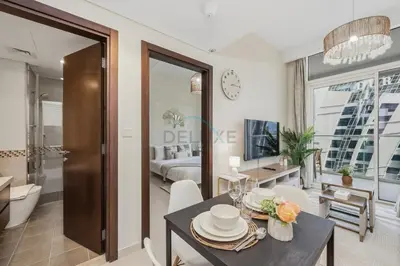 a living room with a dining table and a bedroom at Located Near Dubai Mall, Burj Khalifa and Dubai Canal, with Easy Access to Dubai Metro - Vera Tower, Business Bay by Deluxe Holiday Homes in Dubai