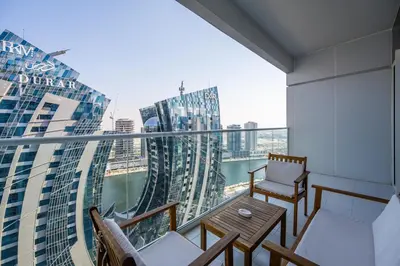 a balcony with a table and chairs on a building at Located Near Dubai Mall, Burj Khalifa and Dubai Canal, with Easy Access to Dubai Metro - Vera Tower, Business Bay by Deluxe Holiday Homes in Dubai