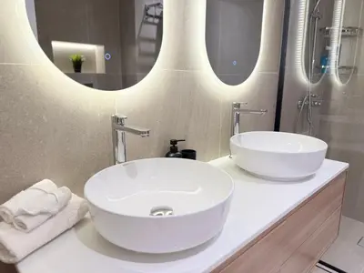 a bathroom with two sinks and two mirrors at Marina Luxury 2 Bedroom Boutique Apartment in Dubai