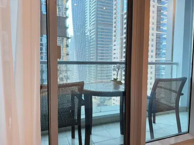a table and chairs on a balcony with a view of a city at Marina Luxury 2 Bedroom Boutique Apartment in Dubai
