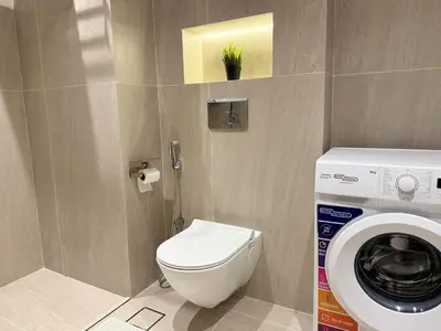 a bathroom with a toilet and a washing machine at Marina Luxury 2 Bedroom Boutique Apartment in Dubai