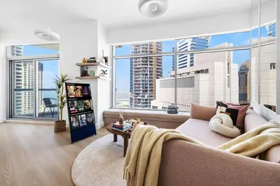 a living room with a couch and a large window at High-Floor 2BR in Dubai Marina with Balcony in Dubai
