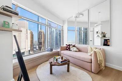 a living room with a couch and a large window at High-Floor 2BR in Dubai Marina with Balcony in Dubai