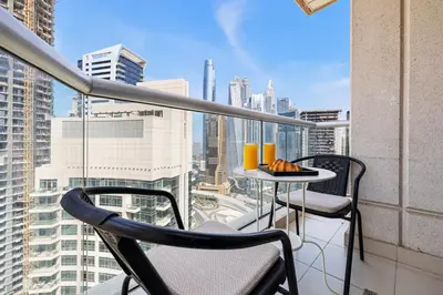 a balcony with two chairs and a table on a building at High-Floor 2BR in Dubai Marina with Balcony in Dubai