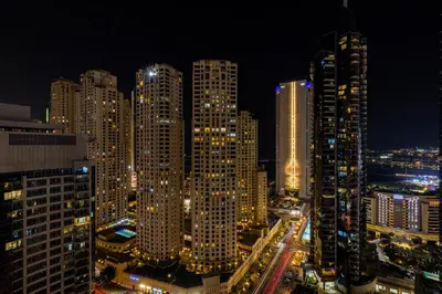 a night view of a city with tall buildings at High-Floor 2BR in Dubai Marina with Balcony in Dubai