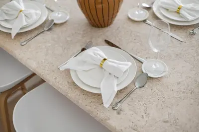 a table topped with white plates and silver spoons at High-Floor 2BR in Dubai Marina with Balcony in Dubai
