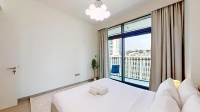 a bedroom with a white bed and a large window at Vacationer l Infinity Pool, Beach Access l 1 Bed in Beach Vista in Dubai