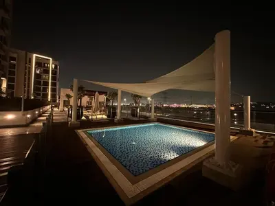 a swimming pool on top of a building at night at Stunning 1 Bed in Meydan in Dubai