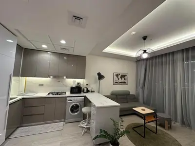 a kitchen and a living room with a couch and a table at Stunning 1 Bed in Meydan in Dubai