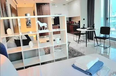 a living room with a shelving unit with a white horse on it at Stylish Studio in J One, near Burj Khalifa, Mall in Dubai