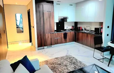 a living room with a white couch and a kitchen at Stylish Studio in J One, near Burj Khalifa, Mall in Dubai