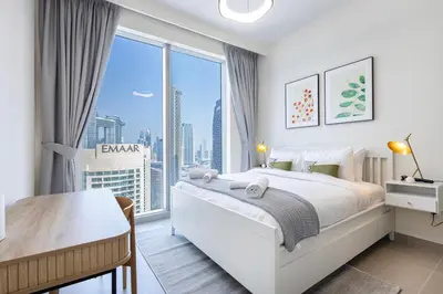 a bedroom with a bed and a large window at Forte Tower 2 - 3 Bedroom with Maid's Room Apartment - Allsopp & Allsopp in Dubai