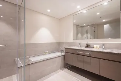 a bathroom with a tub and a sink and a mirror at Forte Tower 2 - 3 Bedroom with Maid's Room Apartment - Allsopp & Allsopp in Dubai