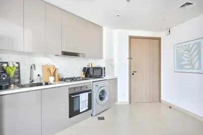 a kitchen with a sink and a washing machine at Frank Porter - Azizi Park Avenue in Dubai