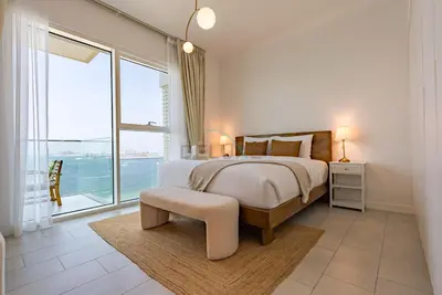 a bedroom with a bed and a large window at Beachfront Stay with Full Sea Views, Walking Distance to The Walk, JBR Beach, and Dubai Marina - La Vie, Jumeirah Beach Residence by Deluxe Holiday Homes in Dubai
