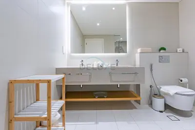 a bathroom with a sink and a toilet and a mirror at Beachfront Stay with Full Sea Views, Walking Distance to The Walk, JBR Beach, and Dubai Marina - La Vie, Jumeirah Beach Residence by Deluxe Holiday Homes in Dubai