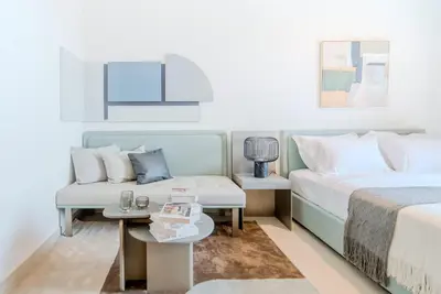 a hotel room with two beds and a couch at TRPS - MAG EYE 970, MBR - Modern and Cozy Studio, Furnished, MBR Living in Dubai
