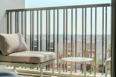 a chair and a table on a balcony with a view at TRPS - MAG EYE 970, MBR - Modern and Cozy Studio, Furnished, MBR Living in Dubai
