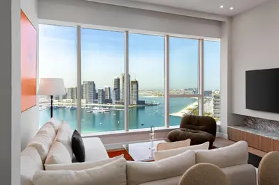 a living room with white furniture and large windows at Maison Privee - High-Floor Haven with Open Sea Views on Palm Entry in Dubai