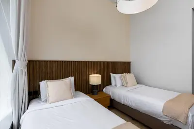 a bedroom with two beds and a lamp on a table at Maison Privee - High-Floor Haven with Open Sea Views on Palm Entry in Dubai