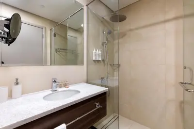 a bathroom with a sink and a shower at Maison Privee - High-Floor Haven with Open Sea Views on Palm Entry in Dubai