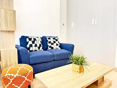 a blue couch in a living room with a coffee table at Elegant Studio in JVC in Dubai