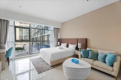 a hotel room with a bed and a couch at Stylish Studio with Rooftop Pool on the Palm in Dubai