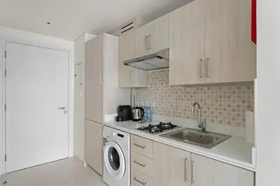 a kitchen with a sink and a washing machine at Stylish Studio with Rooftop Pool on the Palm in Dubai