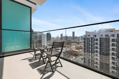 a balcony with a table and chairs on a balcony at Chic Studio with Balcony, Gym & Pools in JVC in Dubai
