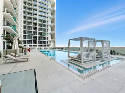 an image of a swimming pool in a building at Chic Studio with Balcony, Gym & Pools in JVC in Dubai
