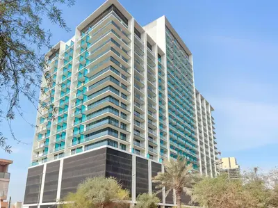an image of a tall building with blue windows at Chic Studio with Balcony, Gym & Pools in JVC in Dubai